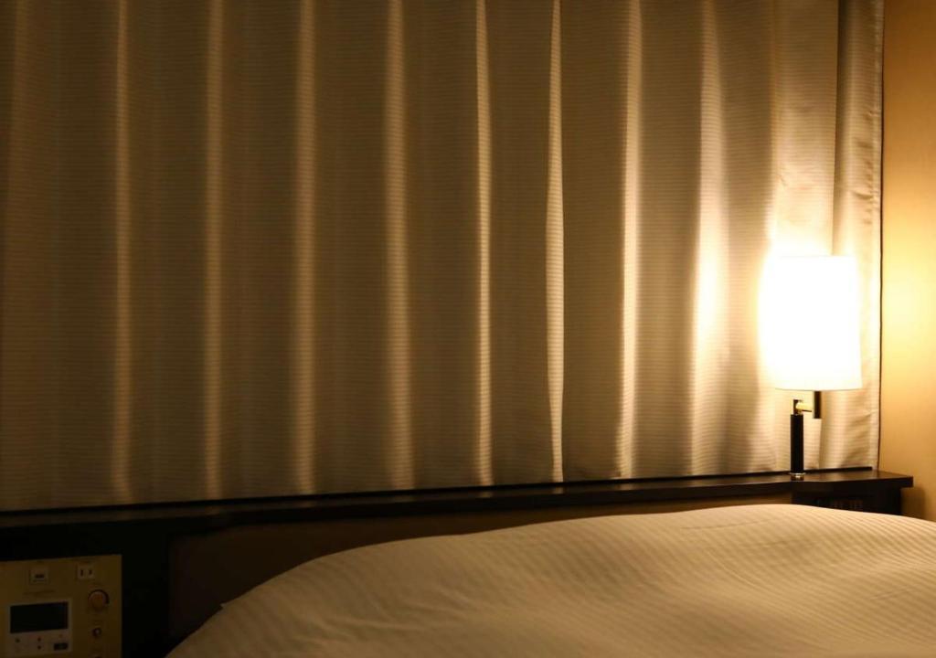 Postel nebo postele na pokoji v ubytování APA Hotel Nagoya Ekimae