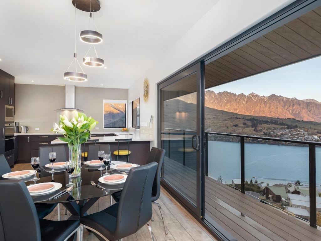 a dining room with a table and views of the mountains at Classy Conifer by Relaxaway Holiday Homes in Queenstown