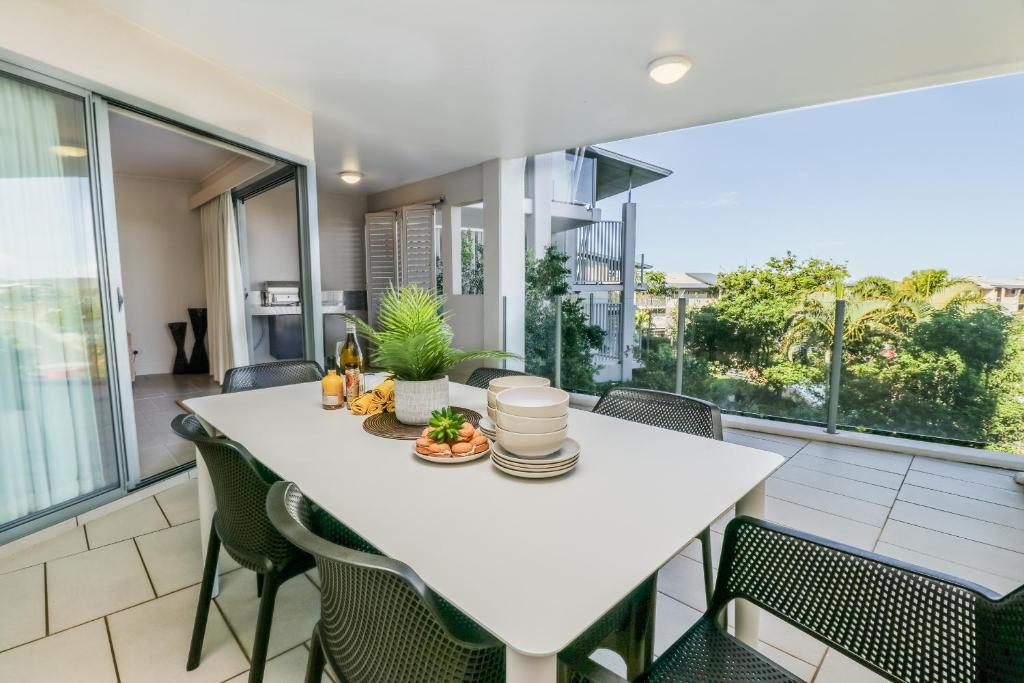 a dining room with a white table and chairs at Avalon 114 Beachside Holiday Apartment in Agnes Water