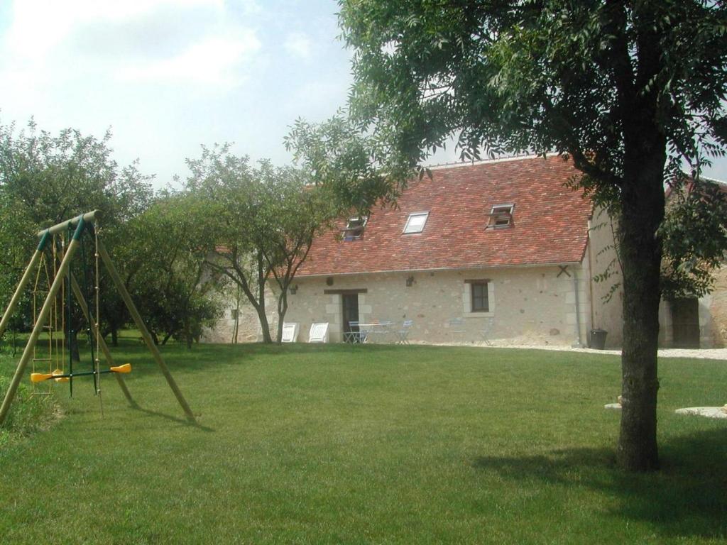 um quintal com um baloiço em frente a uma casa em Gîte Betz-le-Château, 4 pièces, 7 personnes - FR-1-381-365 em Betz-le-Château