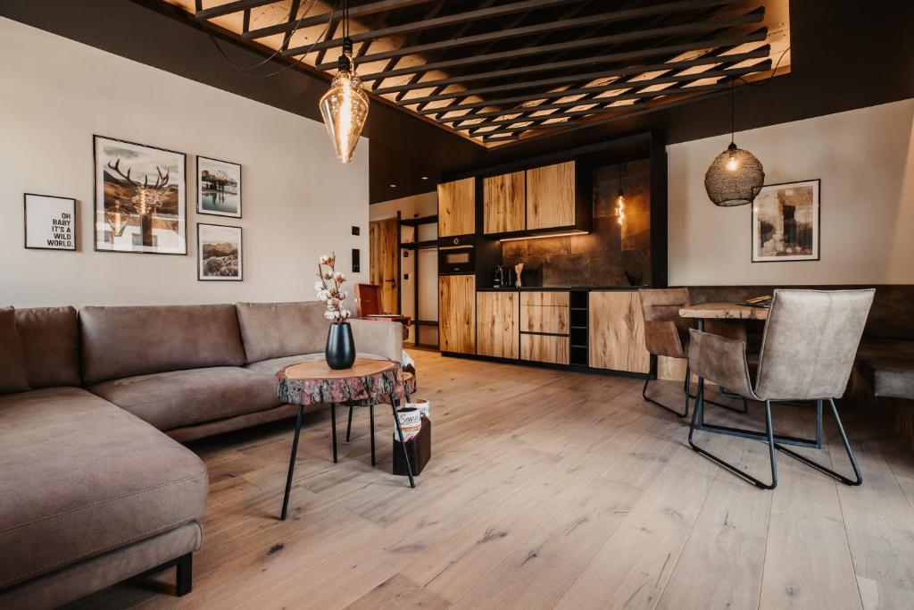 een woonkamer met een bank en een tafel bij Hoamat House I Boutique Apartments in Sankt Margarethen im Lungau