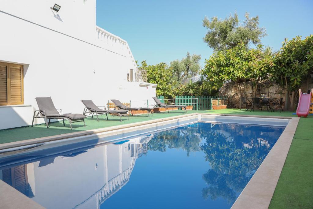 - une piscine avec 2 chaises à côté d'une maison dans l'établissement Masseria Piccola Convertino by Apulia Hospitality, à Faccia di Trippa