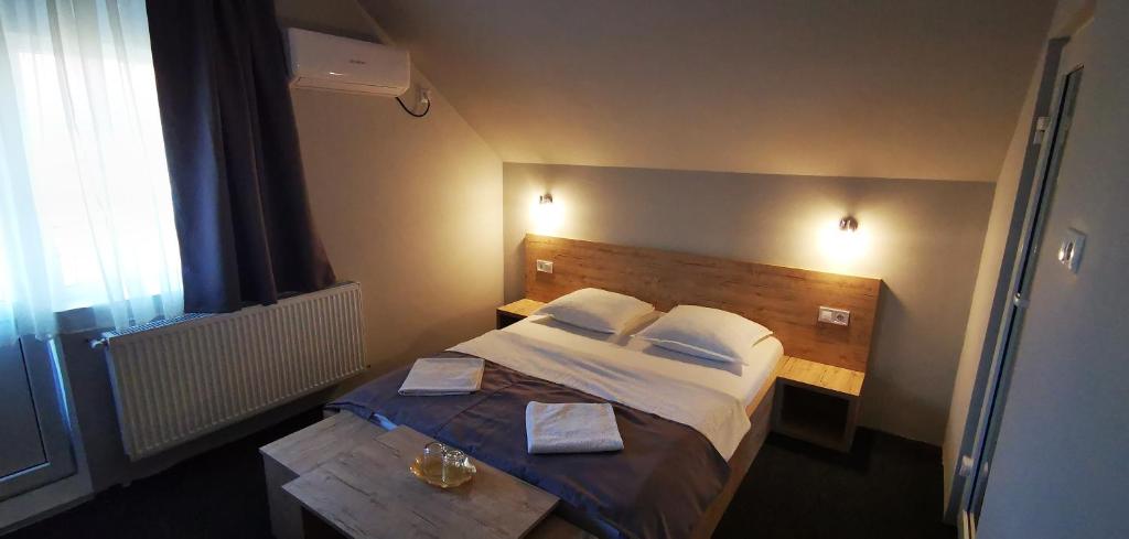 a bedroom with a large bed with a wooden headboard at Pensiunea Chrisland in Oradea