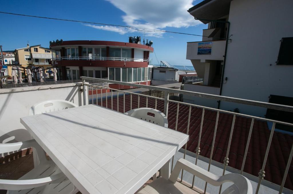 - Balcón con mesa blanca y sillas en M116 - Marcelli, bilocale in centro e fronte mare, en Marcelli