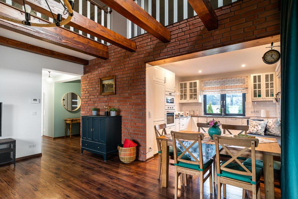 a kitchen and dining room with a brick wall at Willa Spokojne Wzgórze in Pławna