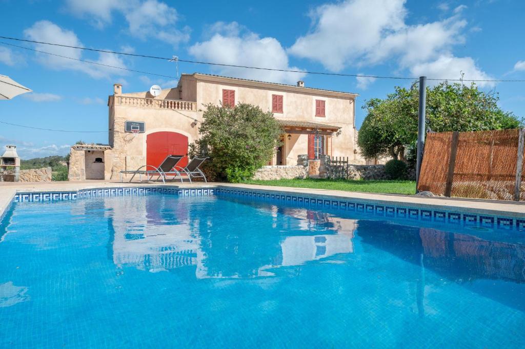a villa with a swimming pool in front of a house at Ses Comes de Son Cladera in Manacor