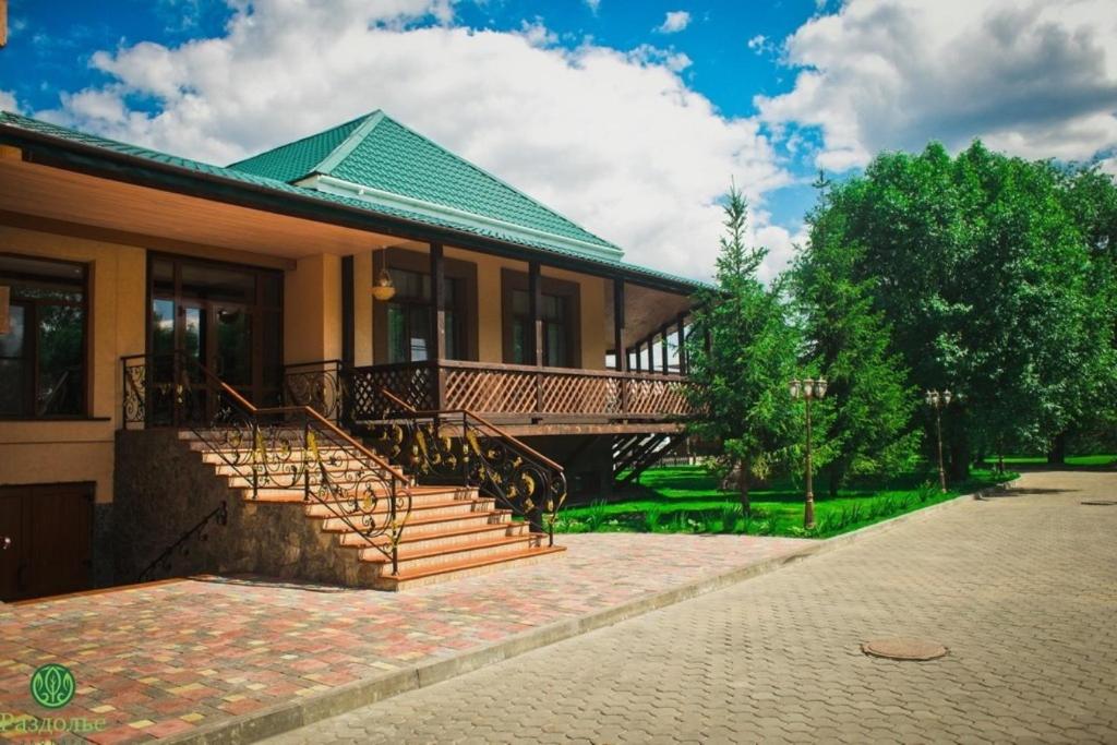una casa con escaleras y techo verde en Hotel in Ecopark Razdolye, en Omsk