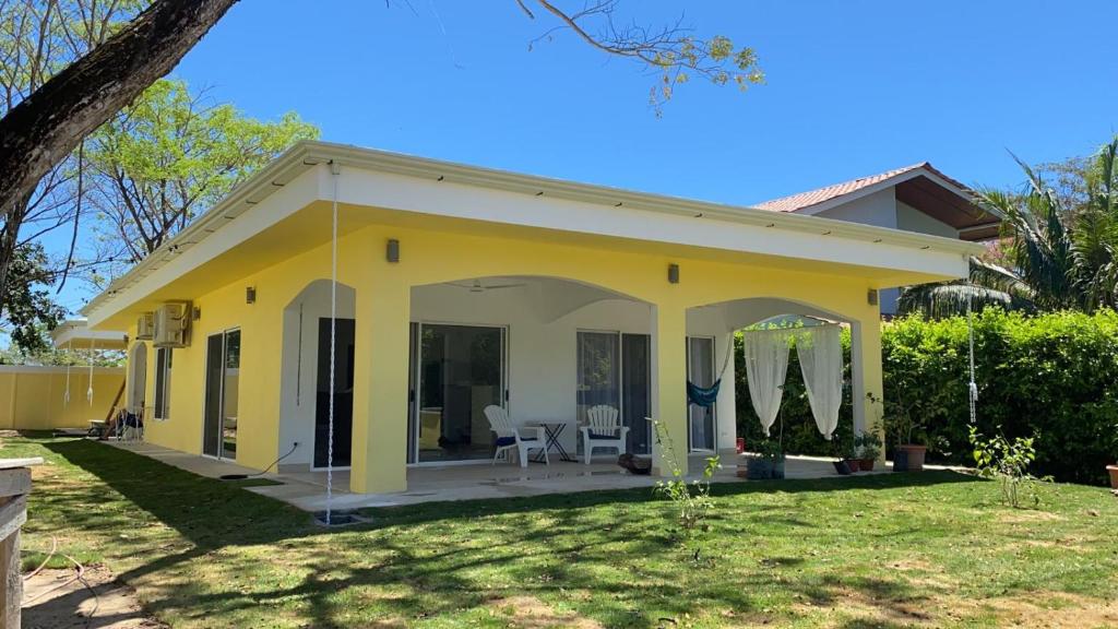 a yellow house with a patio in a yard at Peaceful and beautiful Casa Almita Bonita in Sámara