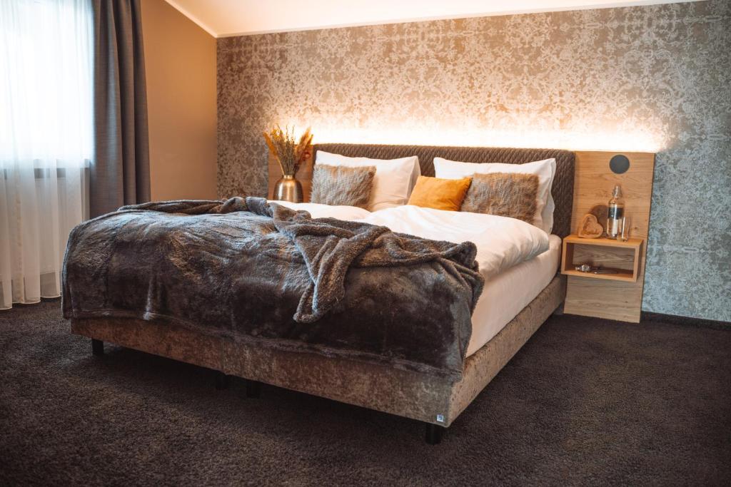 ein Schlafzimmer mit einem großen Bett mit einer Decke darauf in der Unterkunft Mountainview Apartments in Westendorf