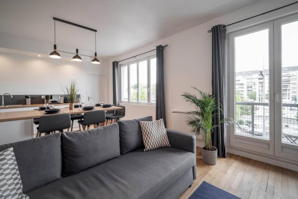 un salon avec un canapé et une salle à manger dans l'établissement APPT VUE SUR LE PORT DE CAEN/ CENTRE VILLE PREMIUM, à Caen