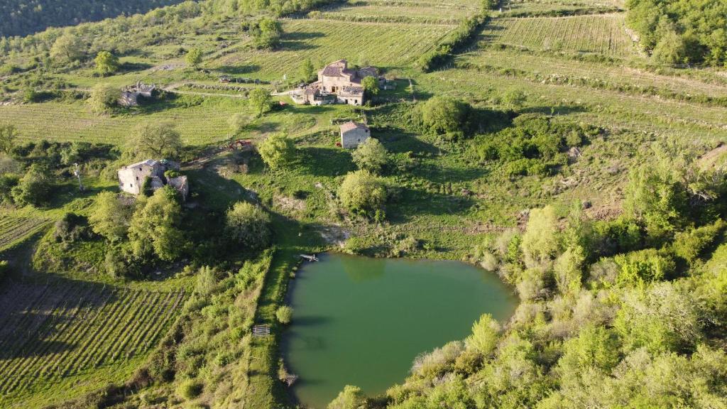 z góry widok na dom na wzgórzu obok jeziora w obiekcie Agriturismo Podere Tegline w mieście Radda in Chianti