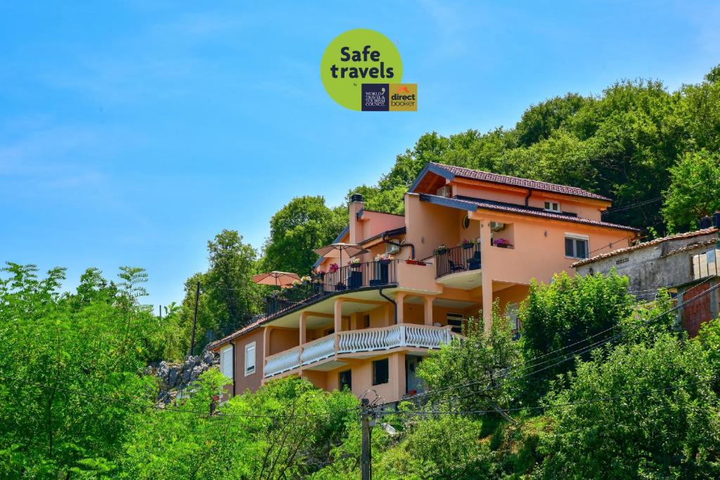 a building on the side of a hill with trees at Lakeview Apartments Anđela in Virpazar