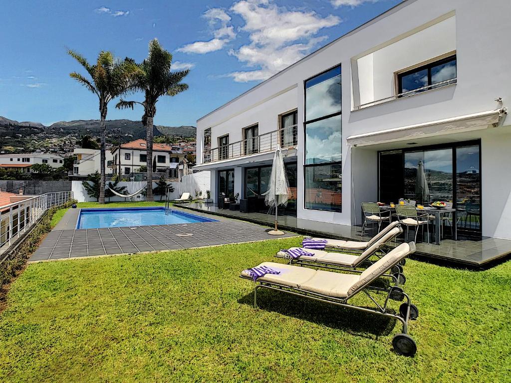 una casa con piscina y 2 tumbonas en el patio en The White House - By LovelyStay, en Funchal