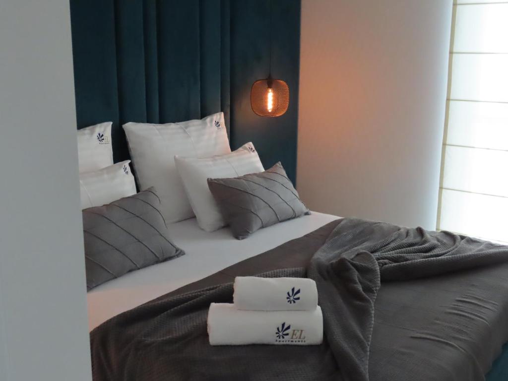 1 dormitorio con 1 cama grande con almohadas en EL Apartments - Solaris en Poznan