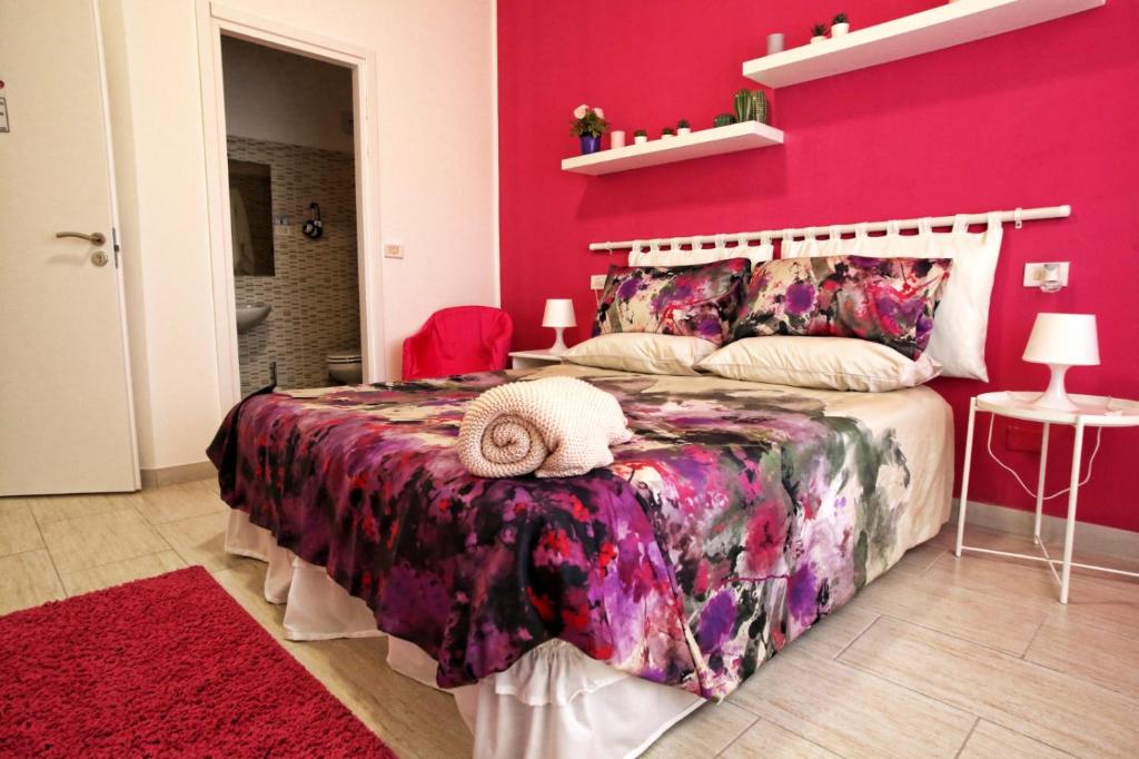 um quarto com uma parede rosa e uma cama em Maison Floria Locazione Turistica em Pescara