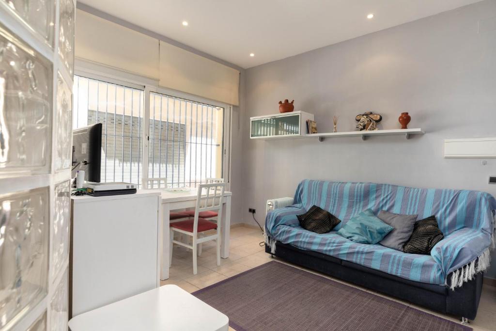 a living room with a couch and a desk at Hauzify I Apartament Subirats in Sant Feliu de Guíxols