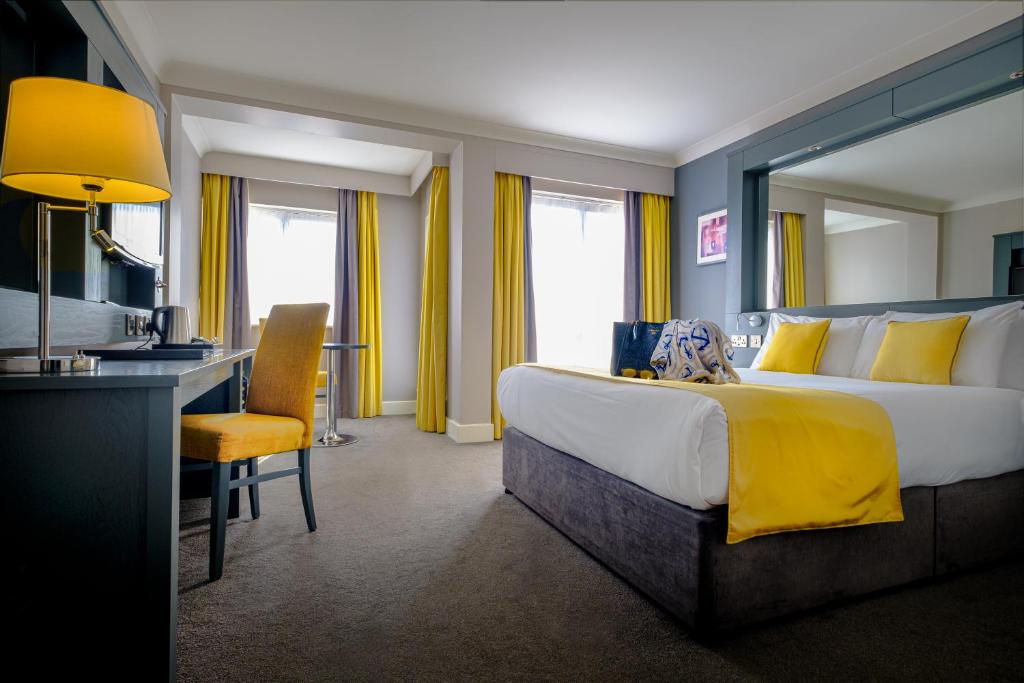 a hotel room with a large bed and a desk at Claregalway Hotel in Claregalway