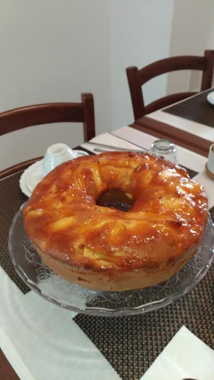 a glazed donut on a glass plate on a table at B&B DIMORA PALMIERI in Monopoli