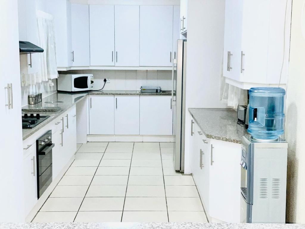 a white kitchen with white cabinets and appliances at C&C HOTEL VIBES Randpark Ridge JHB 14 Units Available in Boskruin