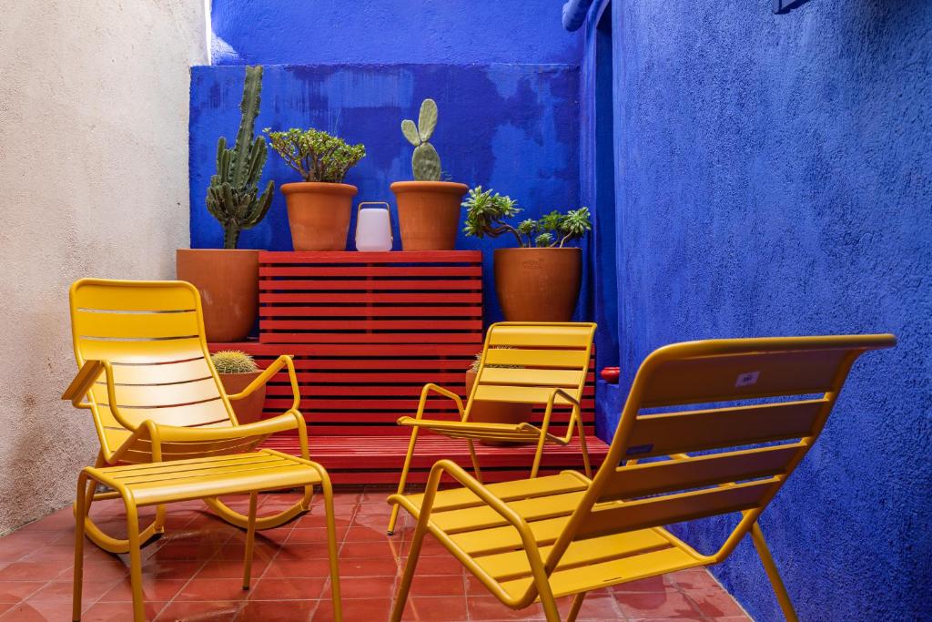 three chairs and a table with potted plants on it at Appartement 5*, Climatisé, avec Terrasse au quartier Le Panier in Marseille