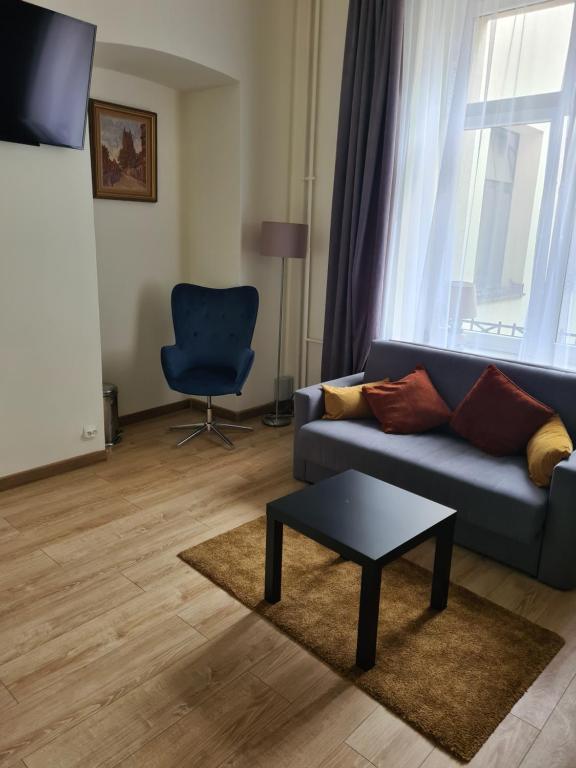 AMBER APARTAMENt #12 في كراكوف: غرفة معيشة مع أريكة زرقاء وطاولة