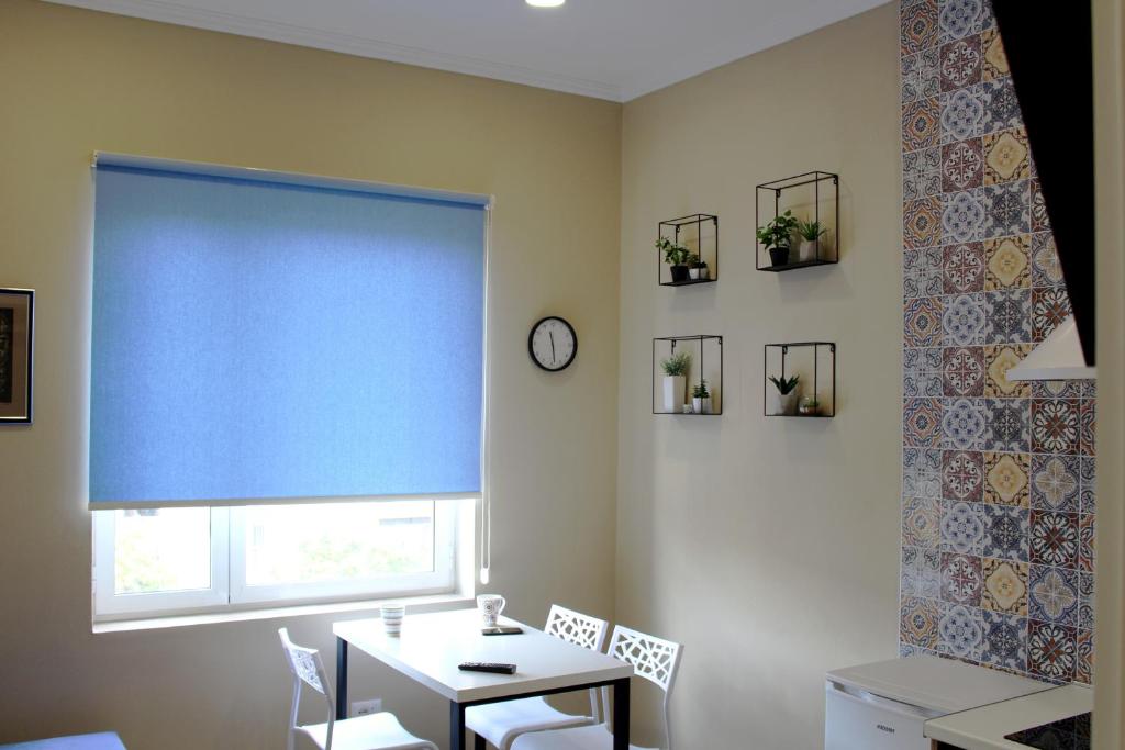 地拉那的住宿－2V1 - Myslym Shyri，一间设有桌子和蓝色窗户的用餐室