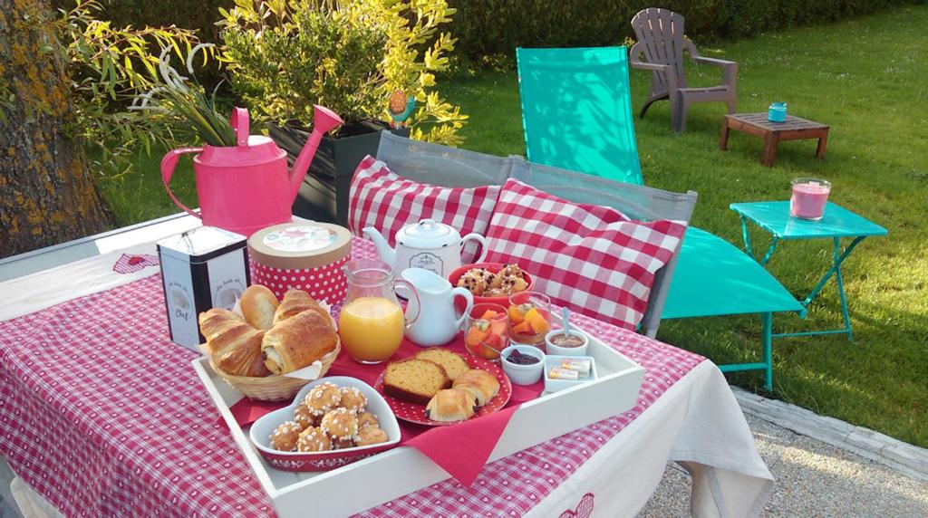 een picknicktafel met een dienblad met eten erop bij O Douceurs Sucrées Cabourg in Cabourg