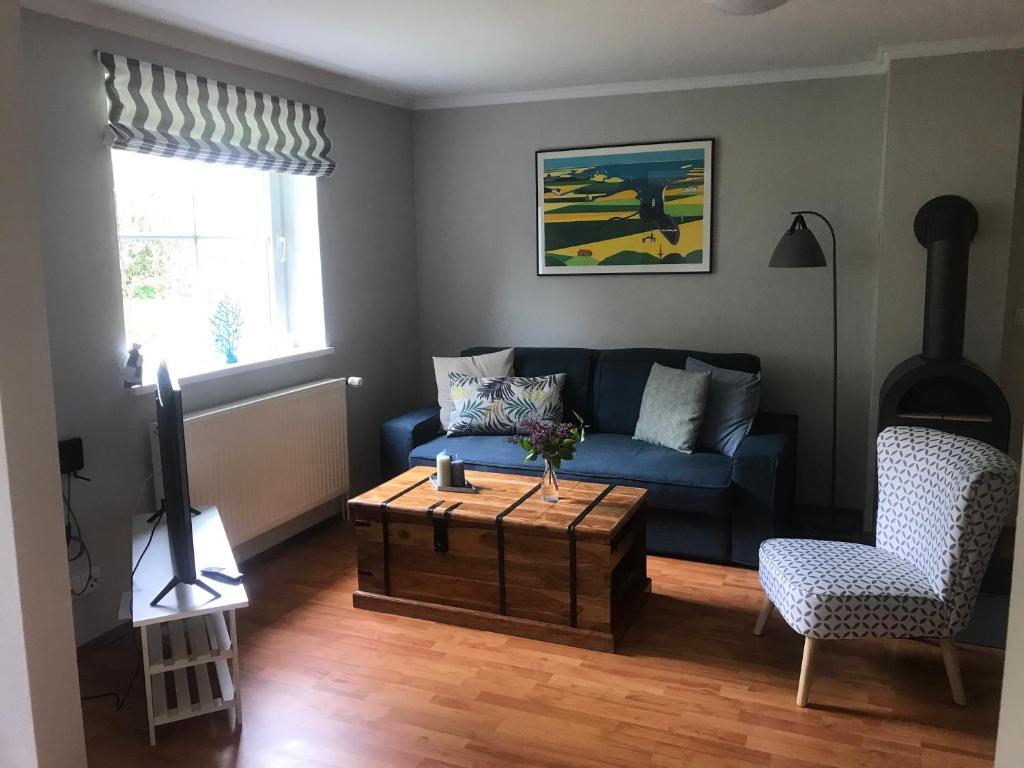 a living room with a blue couch and a coffee table at Refugium in Ostseenähe in Surendorf