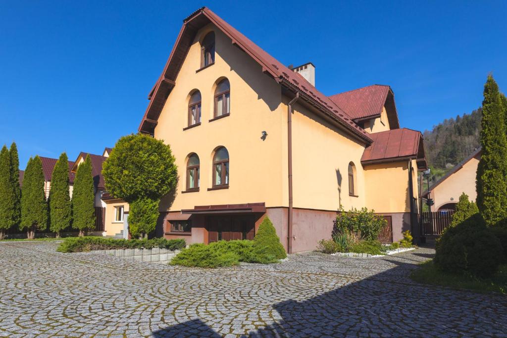 ein großes Haus in einer Kopfsteinpflasterstraße in der Unterkunft Willa Maria in Muszyna