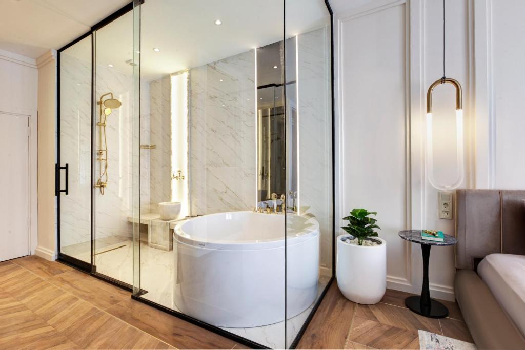 a bathroom with a tub and a glass shower at Walton Gardens Pera in Istanbul