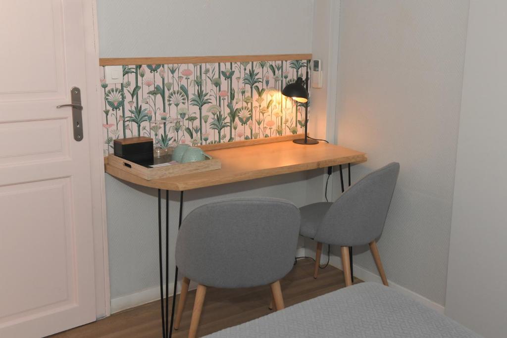 a room with a desk with two chairs and a lamp at Chambres d&#39;hôtes Chez Caroline in Colmar