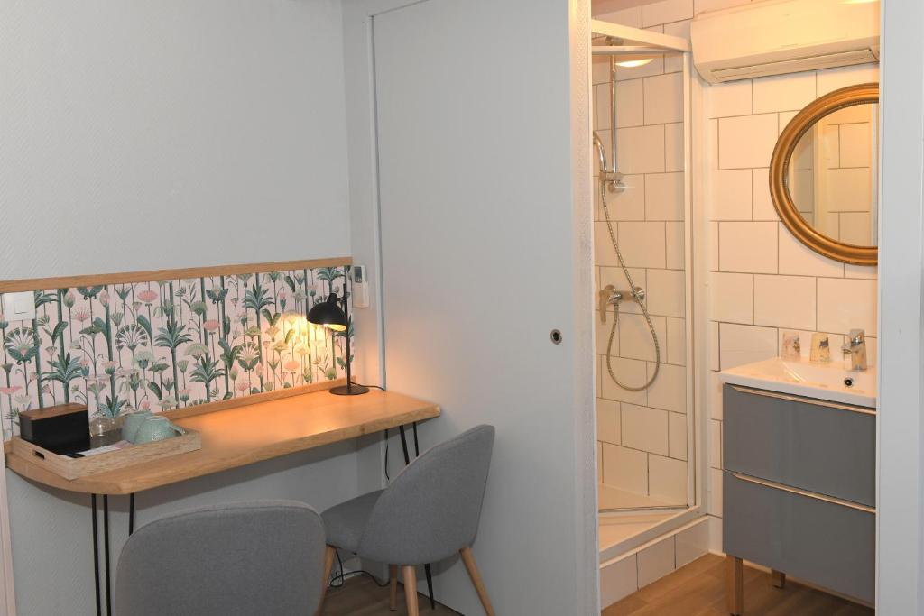 a bathroom with a desk and two chairs and a sink at Chambres d&#39;hôtes Chez Caroline in Colmar