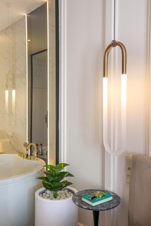 a bathroom with a plant on a table in front of a mirror at Walton Gardens Pera in Istanbul