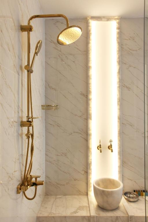a bathroom with a shower with a bowl on a sink at Walton Gardens Pera in Istanbul