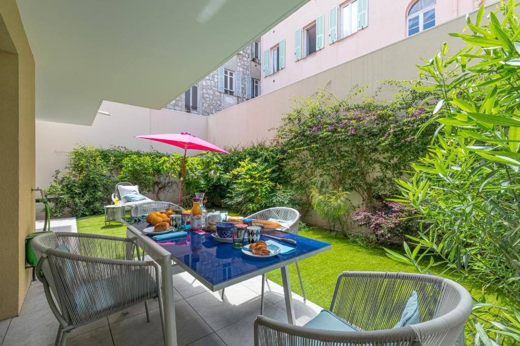 a table with food and an umbrella on a patio at Residence Blue Harmony in Nice