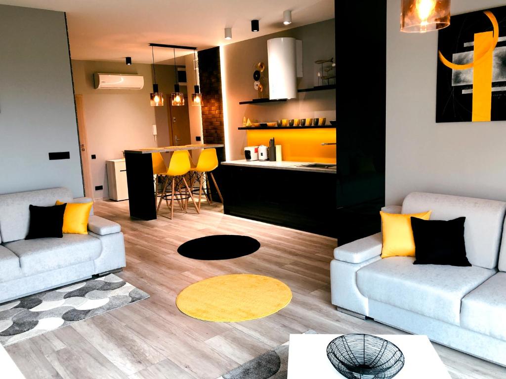 un salon avec deux canapés et une cuisine dans l'établissement APARTAMENT ELEGANCE YELLOW w Nautica Resort, à Giżycko