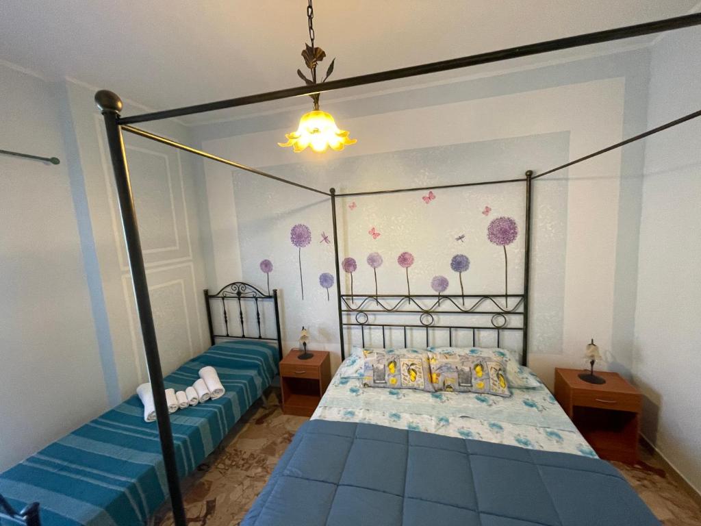 a bedroom with two twin beds with blue sheets at U CURTIGLIU in Realmonte
