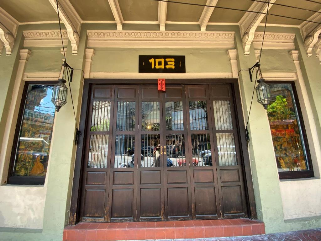 una puerta delantera de un edificio con un reloj encima en 103 - Bed and Brews, en Bangkok