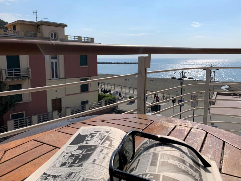 a newspaper sitting on a balcony with a view of the ocean at Case vacanze Miramare in Levanto