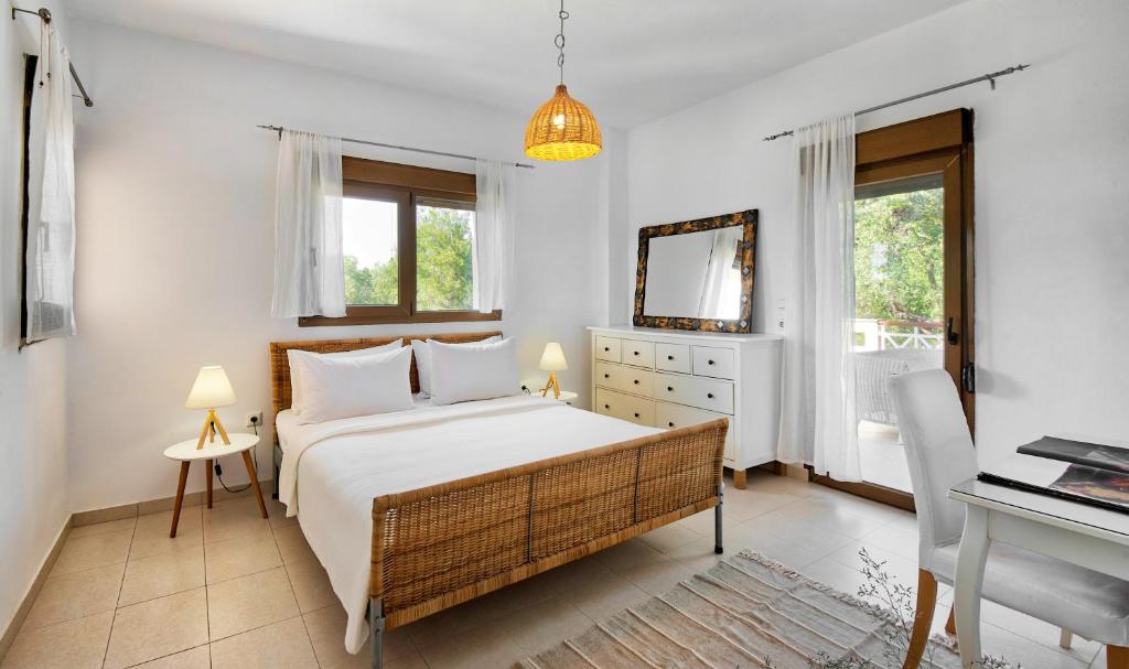 a bedroom with a bed and a desk and window at Sanidiamonds in Sani Beach