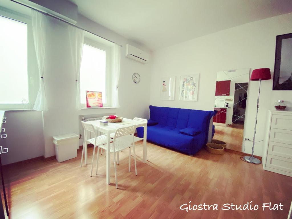 - un salon avec un canapé bleu et une table dans l'établissement Giostra Studio Flat, à Trieste