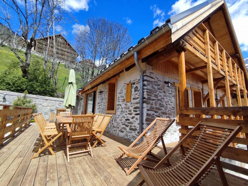 une terrasse en bois avec des chaises et une table dans l&#39;établissement Chalet Le Petit Plus, à Vaujany