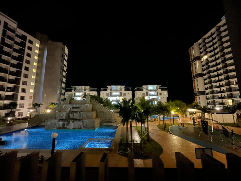 a swimming pool in the middle of a city at night at Awin swiss garden residence in Kuantan