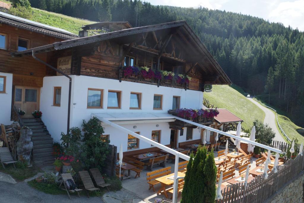 ein Gebäude mit einem Balkon mit Blumen darauf in der Unterkunft Gasthaus Oberkirn in Schenna