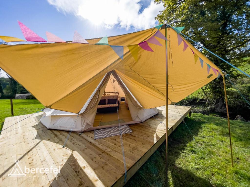 Abercefel Retreat في Llandysul: خيمة كبيرة على سطح خشبي في حقل