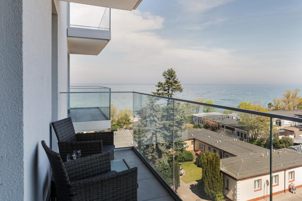 a balcony with chairs and a view of the ocean at Apartamenty Balticus by Renters in Międzyzdroje