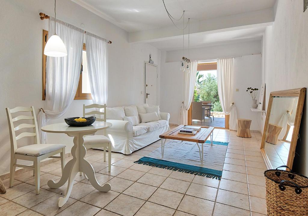 a living room with a white couch and a table at Sanidiamonds in Sani Beach