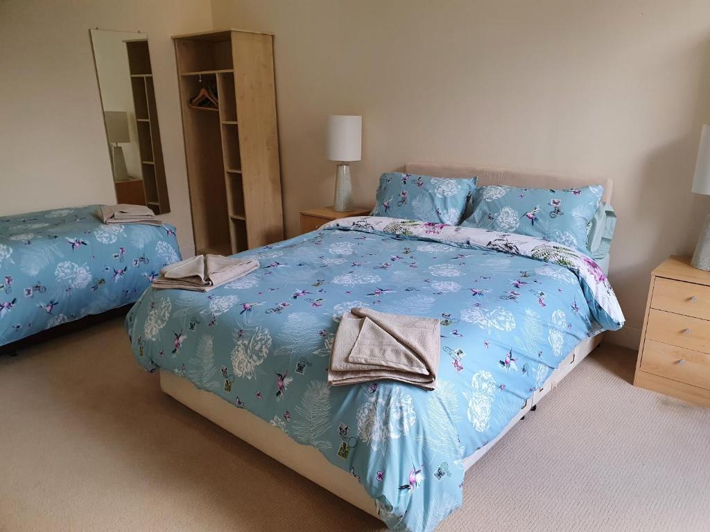 a bedroom with a bed with a blue comforter at Flat 1 Castlebank house Flats in Dingwall