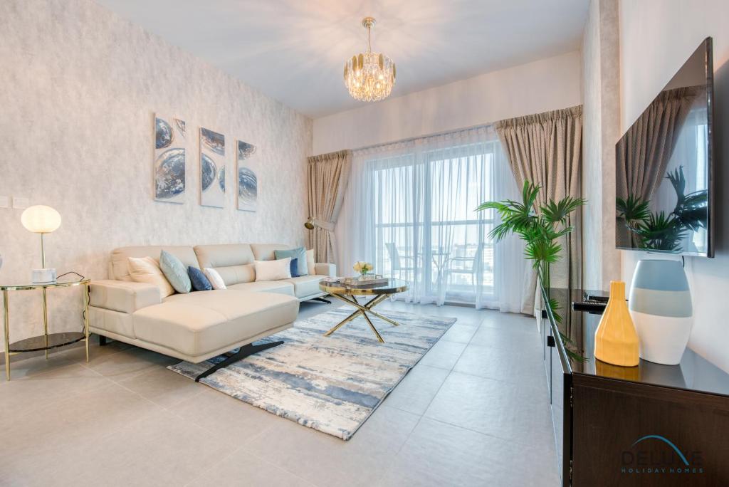 a living room with a couch and a table at Stylish 2BR in Bella Rose Al Barsha South by Deluxe Holiday Homes in Dubai
