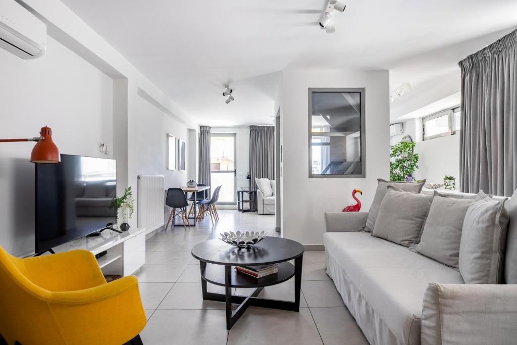 ein Wohnzimmer mit einer weißen Couch und einem gelben Stuhl in der Unterkunft Supreme D1 Penthouse 131m² in Syntagma in Athen